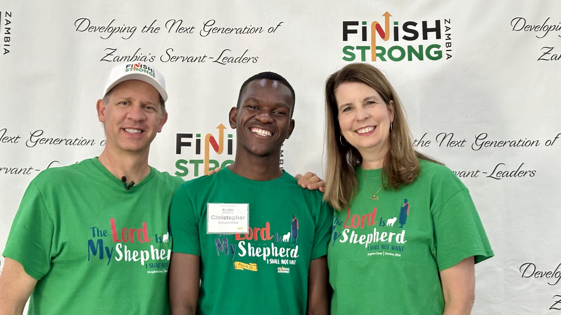 Group posing at Finish Strong event backdrop