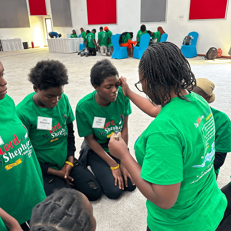 Young girls engage in a group activity wearing green shirts indoors.