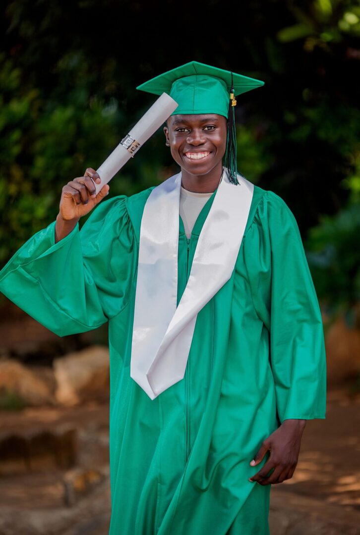 Graduate holding diploma in green gown