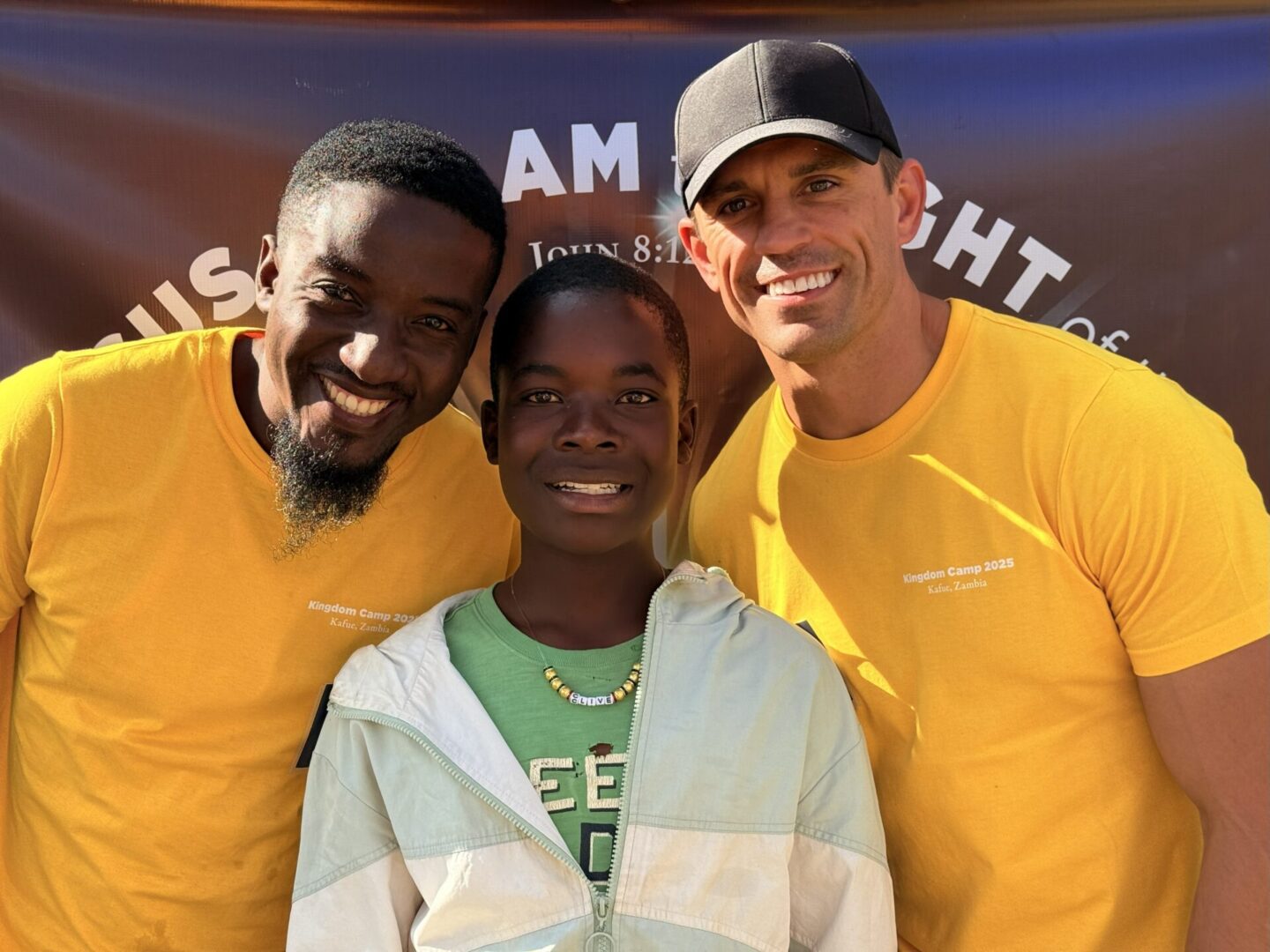 Three people smiling at outdoor event