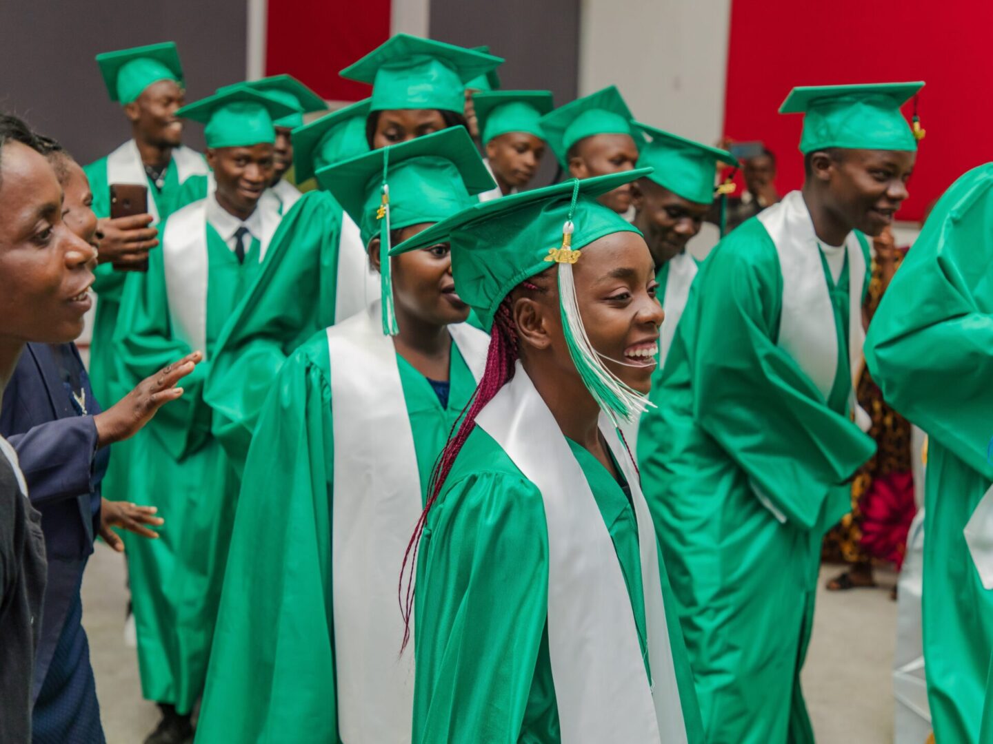 Joyful graduates wearing green and white attire