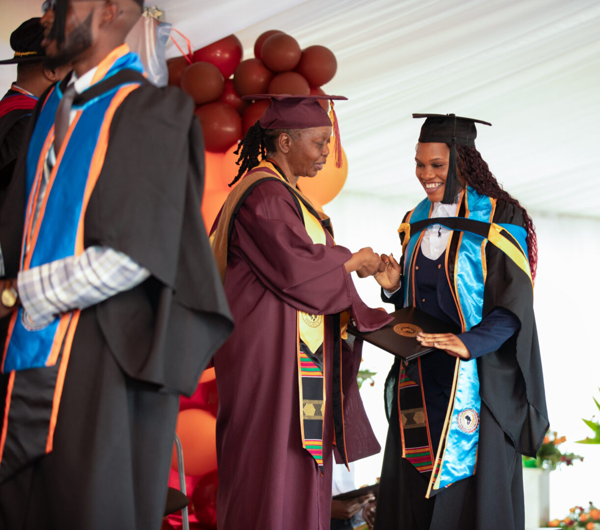 Two graduates shaking hands on stage