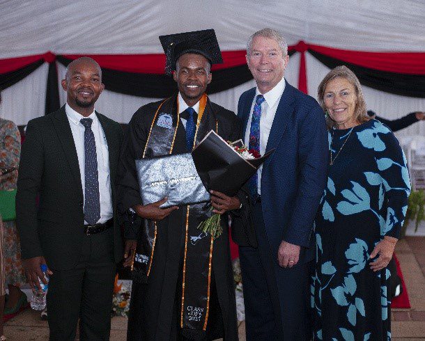 Graduation celebration with proud family and graduate in cap and gown.