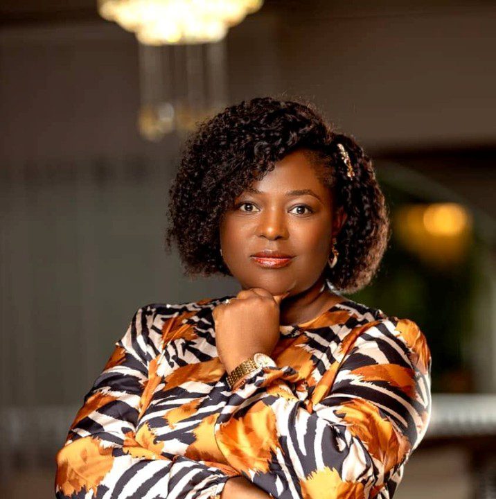 Confident woman with crossed arms in a patterned outfit.