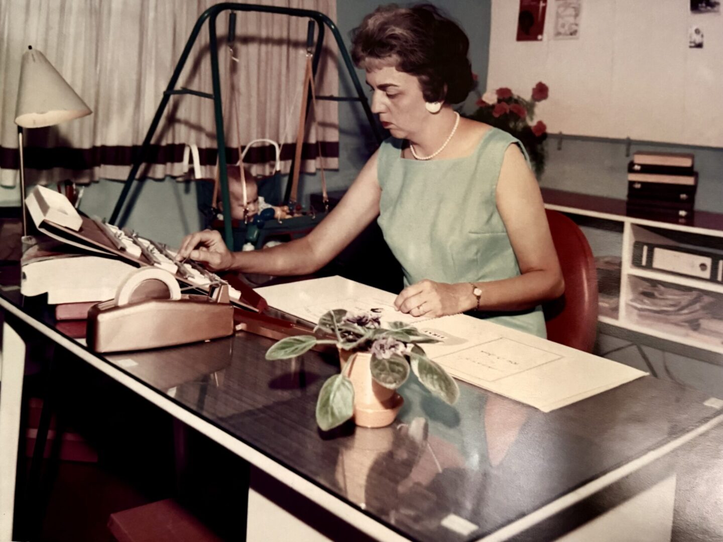 Woman working at a desk with typewriter.