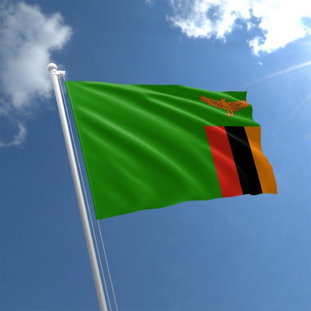 Zambian flag waving against blue sky